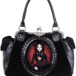 Bolso gótico con muñeca Bolso hecho de terciopelo negro y decorado con cuero sintético. En el centro hay una muñeca gótica impresa digitalmente y rodeada de un marco de piel sintética. En los lados hay dos amplios bolsillos hechos de imitación de cuero. En el interior hay un forro negro y suave con dos bolsillos. Uno grande con cremallera y otro más pequeña.