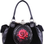 Bolso gótico con rosa roja Bolso hecho de terciopelo negro y decorado con cuero sintético. En el centro hay una rosa roja rodeada de un marco de piel sintética. En los lados hay dos amplios bolsillos hechos de imitación de cuero. En el interior hay un forro negro y suave con dos bolsillos. Uno grande con cremallera y otro más pequeña.